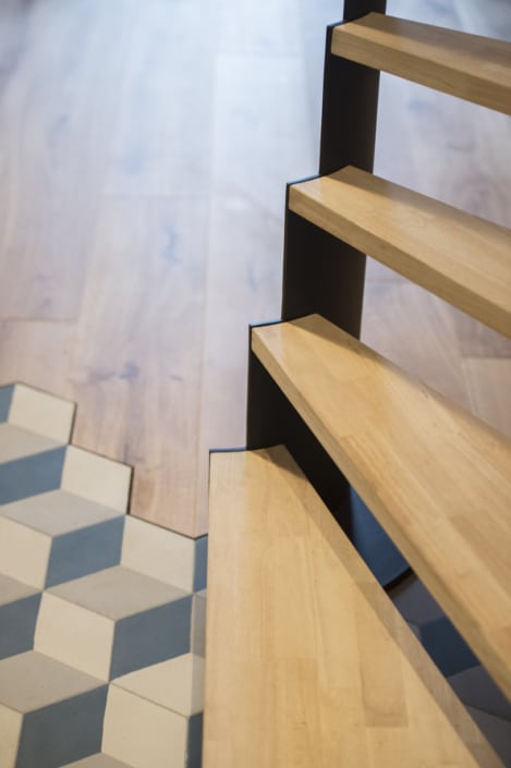 escalier design avec marche en bois clair et limon latéral en acier peint