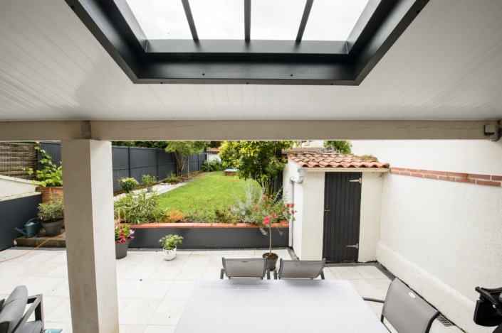 jardin avec terrasse en pierre et toit avec puit de lumiere moderne en metal