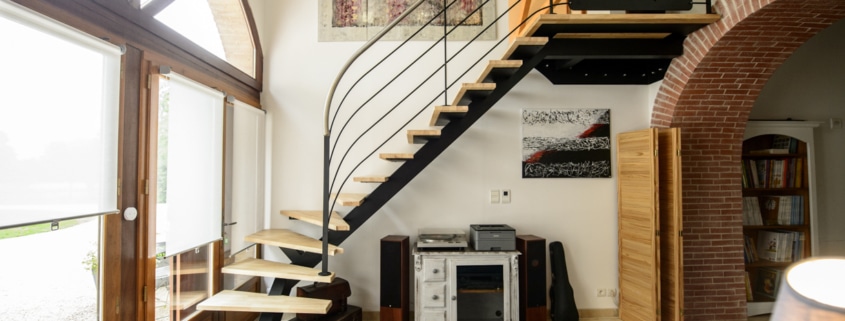 salon avec escalier quart tournant en bois et limon central en metal