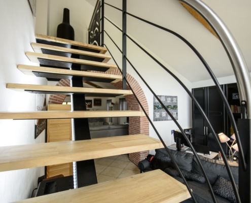 escalier design avec limon central en fer et marche en bois