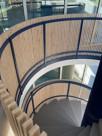 escalier rond moderne avec rampe en métal et en bois