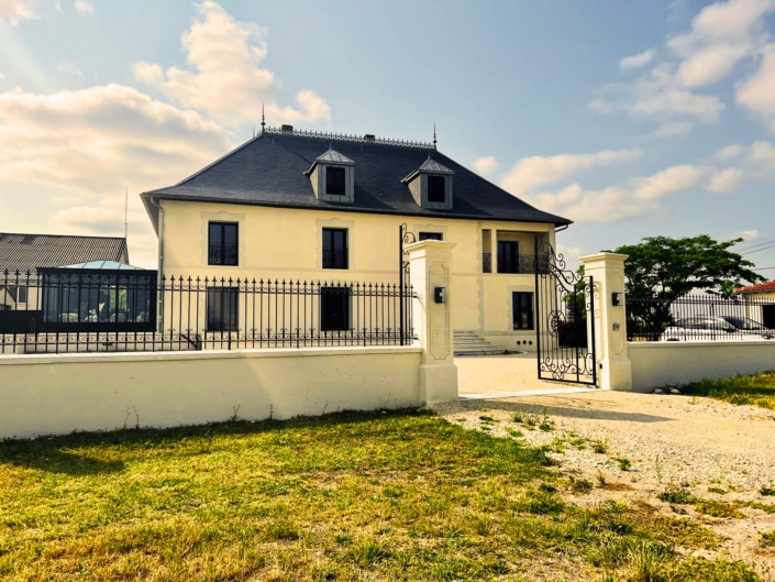 maison avec grand portail et garde-corps en métal